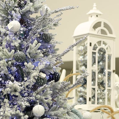Snow White Christmas Tree with blue and white decorations. With container of silver baubles