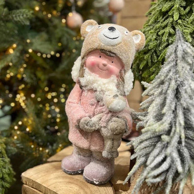 Pink Frosty Girl Ornament holding bear amidst Christmas trees