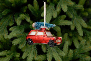 Red car with Christmas tree on top hanging on Christmas tree decoration 