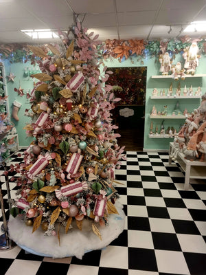 Christmas tree with pink candy decorations in showroom with black and white tiles