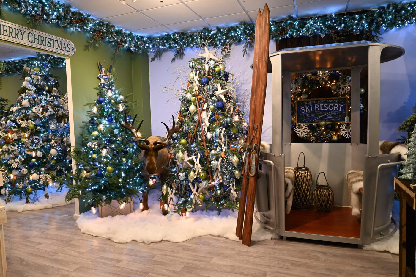 Alpine Ski Lodge Christmas Theme with Reindeer, Christmas Tree and Skis, blue and green colour scheme.
