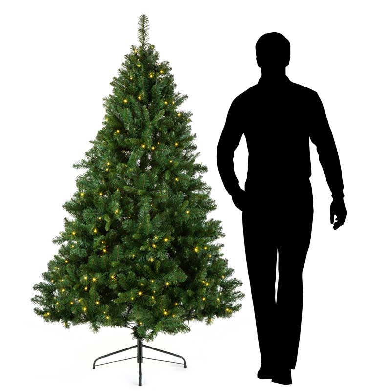 Silhouette of man beside pre lit artificial Christmas Tree