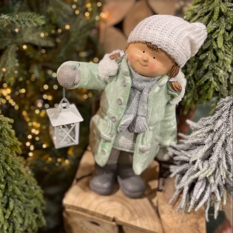 Frosty Girl in green coat and woolly hat figurine holding a lantern